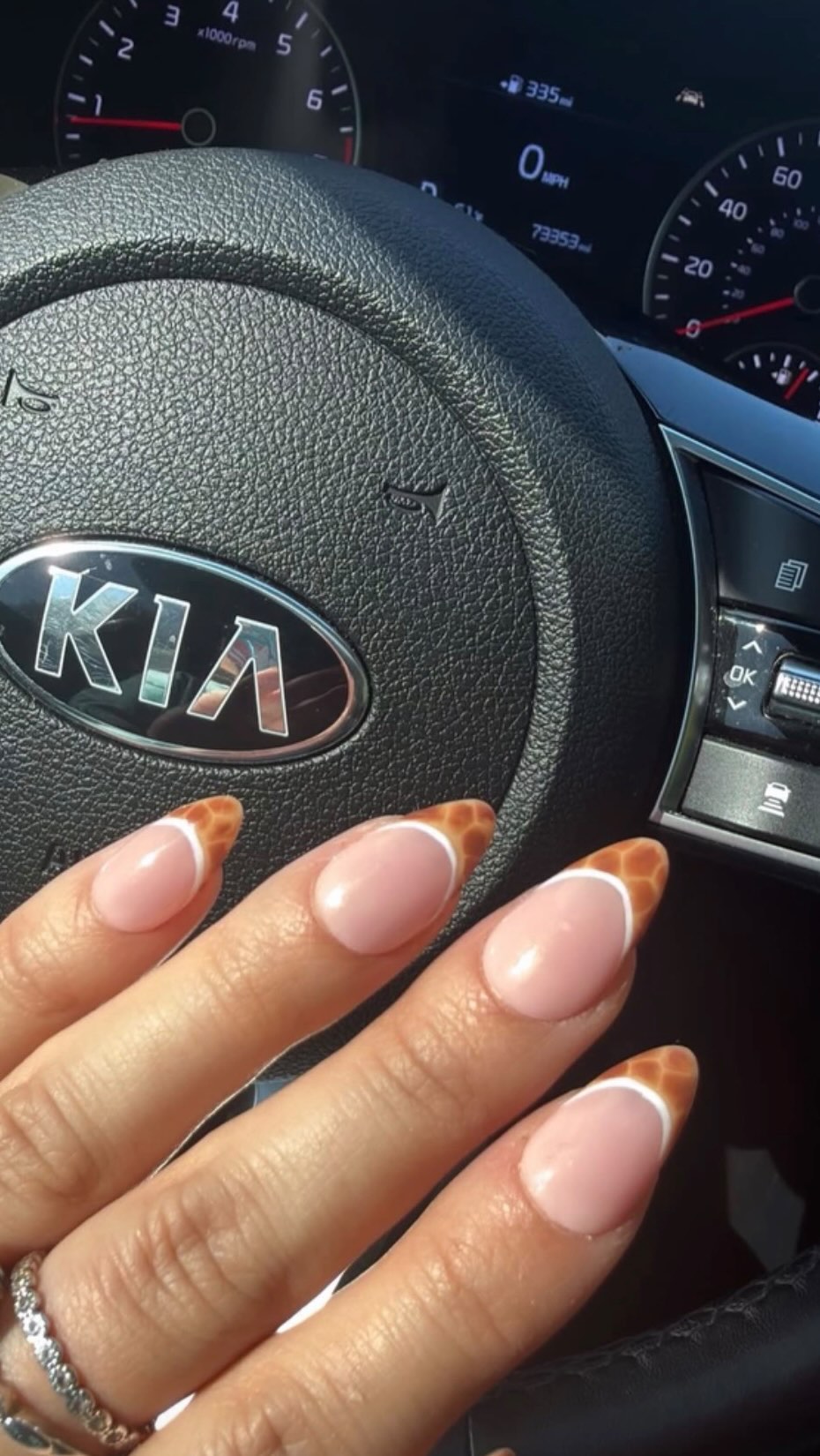 Almond press-ons with a thin white French tip and giraffe-print accents.